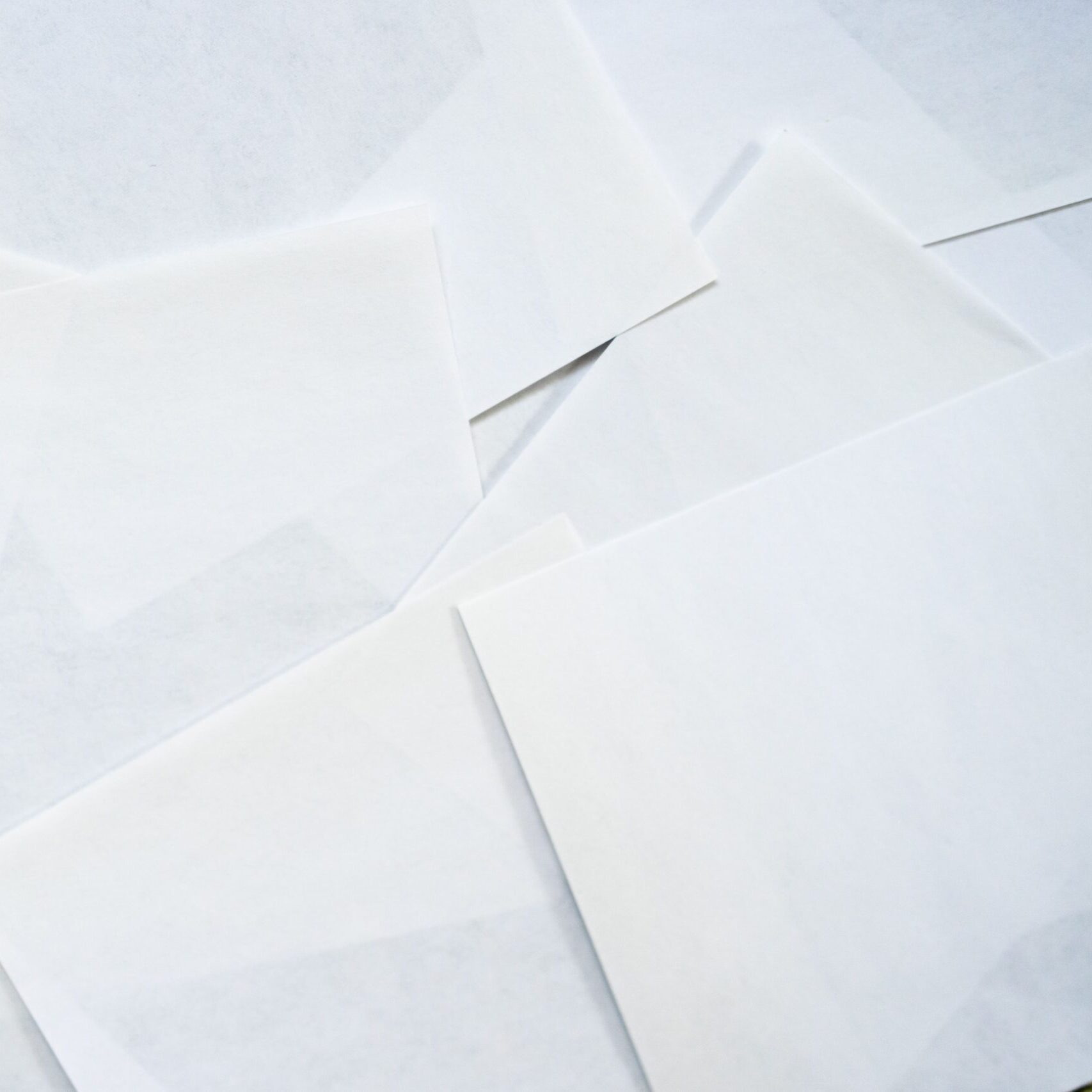 A minimalist arrangement of overlapping white paper sheets creating an abstract texture.